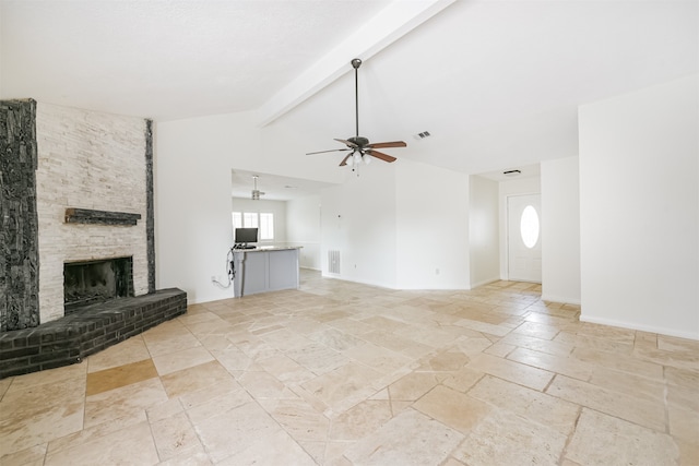 unfurnished living room featuring a stone fireplace, vaulted ceiling with beams, and ceiling fan