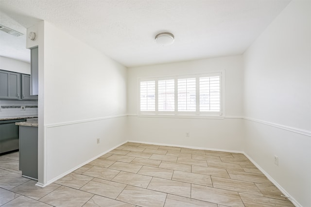 unfurnished room featuring a textured ceiling