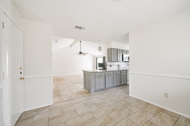 kitchen featuring decorative backsplash, ceiling fan, range, gray cabinetry, and lofted ceiling with beams