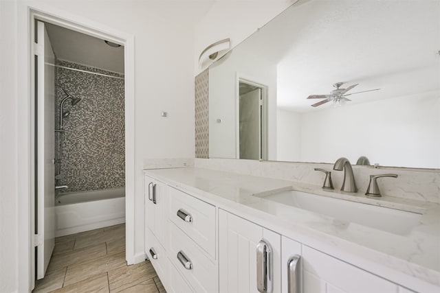 bathroom with tiled shower / bath, vanity, and ceiling fan