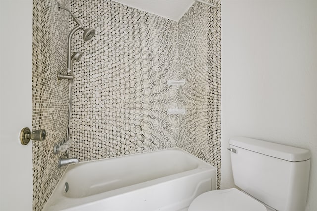 bathroom featuring toilet and tiled shower / bath