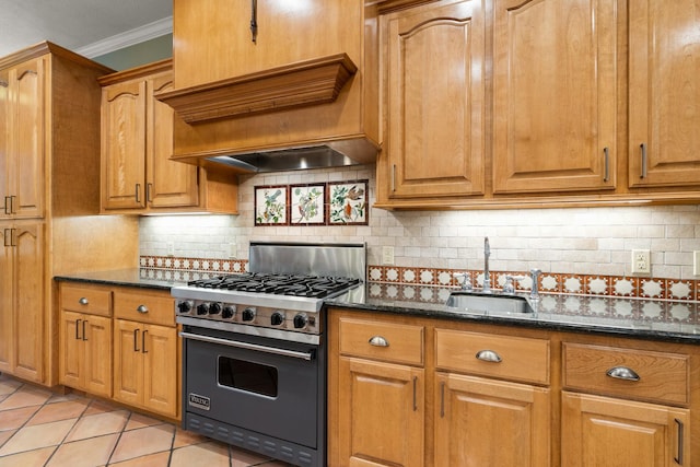 kitchen featuring backsplash, dark stone countertops, luxury range, and sink