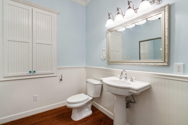 bathroom with wood-type flooring, toilet, and ornamental molding