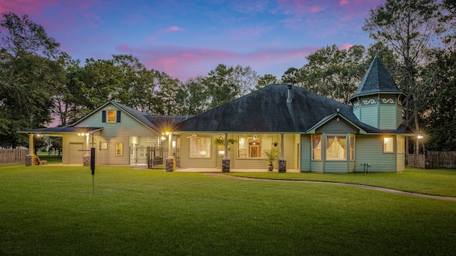 back house at dusk featuring a yard and a carport