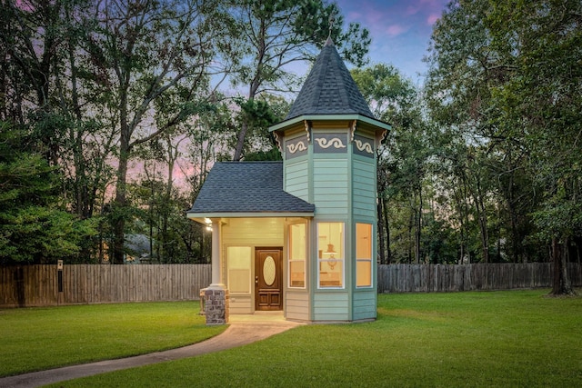 outdoor structure at dusk featuring a lawn