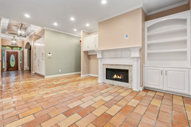 unfurnished living room featuring built in shelves, crown molding, and a fireplace