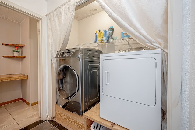 clothes washing area featuring washer and dryer, tile patterned flooring, and a textured ceiling