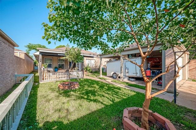 view of yard featuring a porch, a carport, a fire pit, and an outbuilding