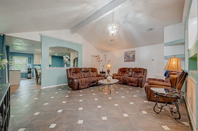 living room featuring lofted ceiling with beams, a textured ceiling, and a chandelier