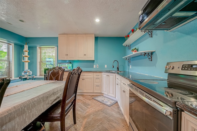 kitchen with ventilation hood, stainless steel electric range, sink, light parquet floors, and a textured ceiling