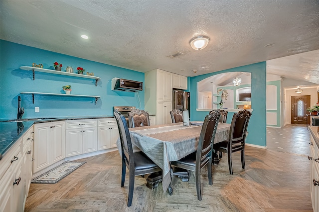 dining space with light parquet flooring, a textured ceiling, and sink