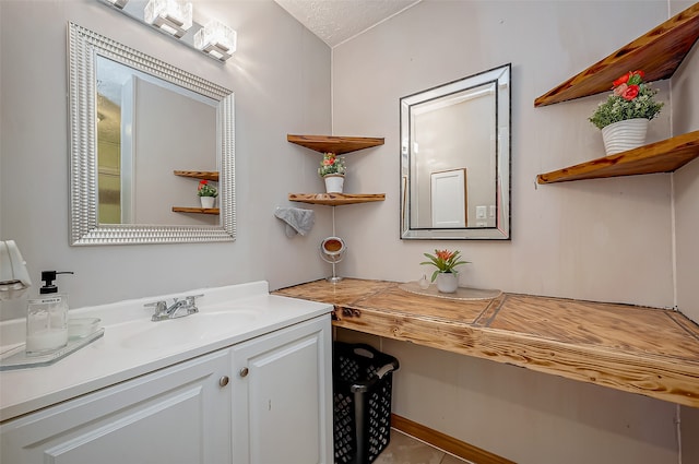 bathroom with a textured ceiling and vanity