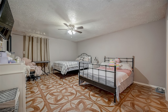 bedroom with a textured ceiling and ceiling fan