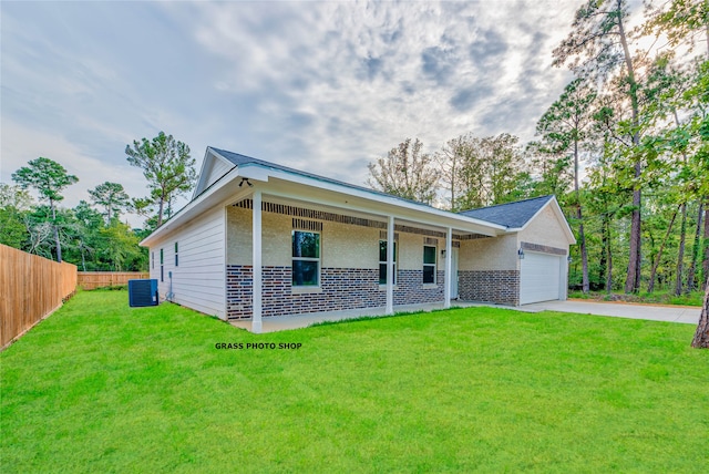 ranch-style home featuring central AC, a garage, a front yard, and a porch