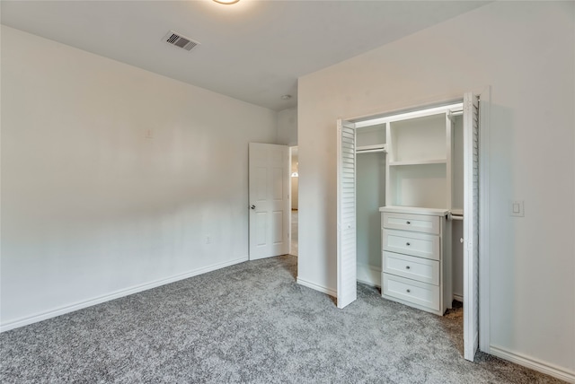 unfurnished bedroom with light colored carpet and a closet