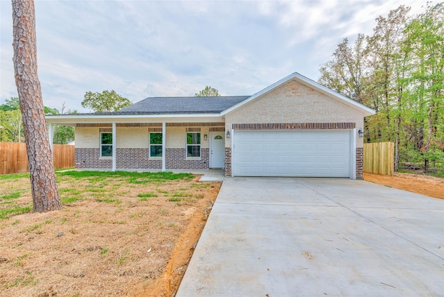 448 Brahman, Onalaska, TX 77360 - ranch-style house with an attached garage, concrete driveway, brick siding, and covered porch