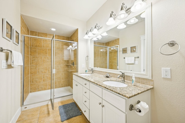 bathroom with tile patterned floors, walk in shower, and vanity