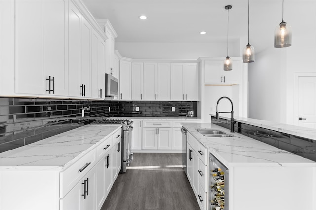 kitchen featuring appliances with stainless steel finishes, hanging light fixtures, sink, and white cabinets