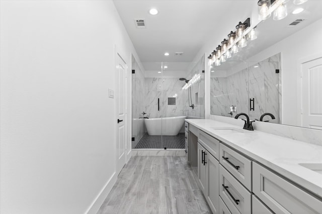 bathroom featuring wood-type flooring, vanity, and shower with separate bathtub