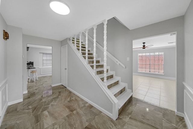 staircase featuring ceiling fan