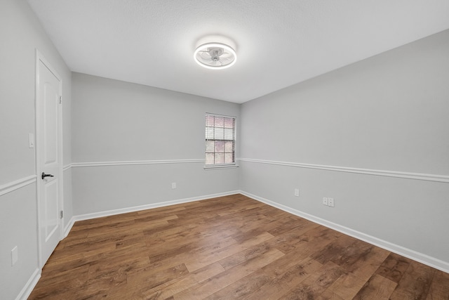 unfurnished room with a textured ceiling and hardwood / wood-style floors