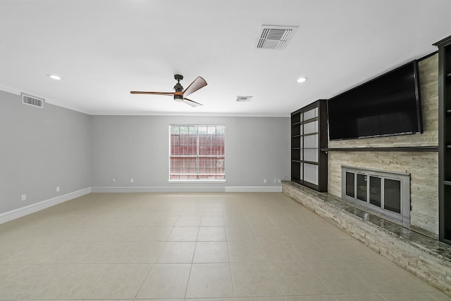 unfurnished living room featuring a fireplace, ornamental molding, light tile patterned floors, and ceiling fan