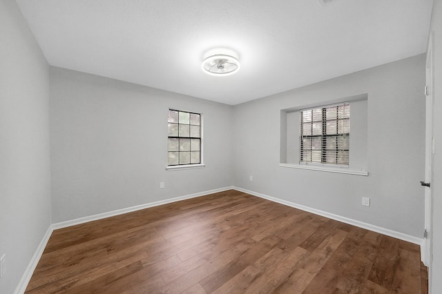 unfurnished room with a wealth of natural light and wood-type flooring