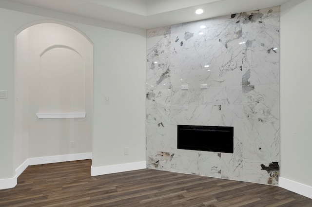 unfurnished living room featuring dark hardwood / wood-style flooring and a high end fireplace