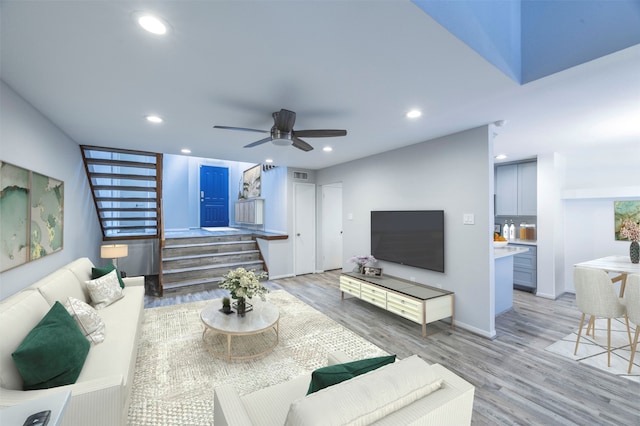 living room with ceiling fan and light hardwood / wood-style flooring