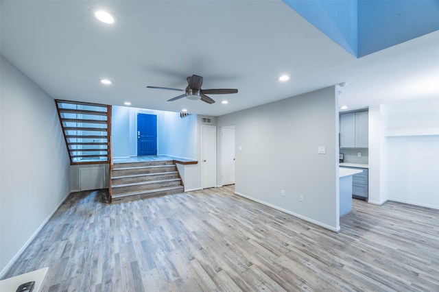 unfurnished living room featuring ceiling fan and light hardwood / wood-style floors