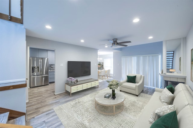 living room featuring light wood-type flooring and ceiling fan