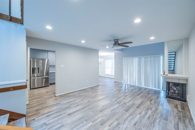 unfurnished living room featuring light hardwood / wood-style floors and ceiling fan