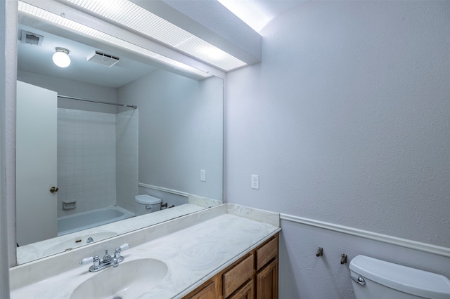 full bathroom featuring tiled shower / bath combo, vanity, and toilet