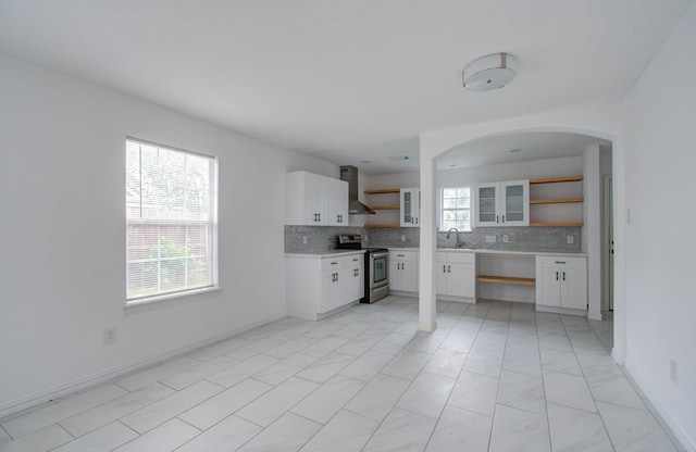 kitchen with plenty of natural light, stainless steel electric stove, and white cabinets