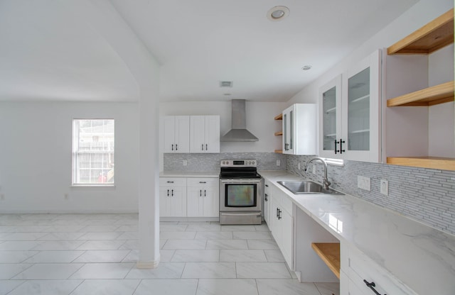 kitchen featuring white cabinets, light stone counters, sink, wall chimney exhaust hood, and stainless steel range with electric cooktop