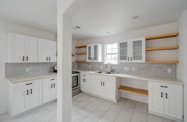 kitchen featuring sink, stainless steel electric range oven, decorative backsplash, and white cabinetry