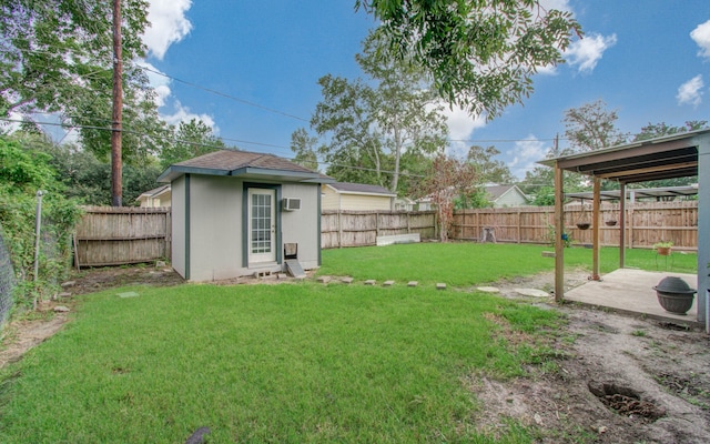 view of yard featuring a storage unit, a wall mounted AC, and a patio