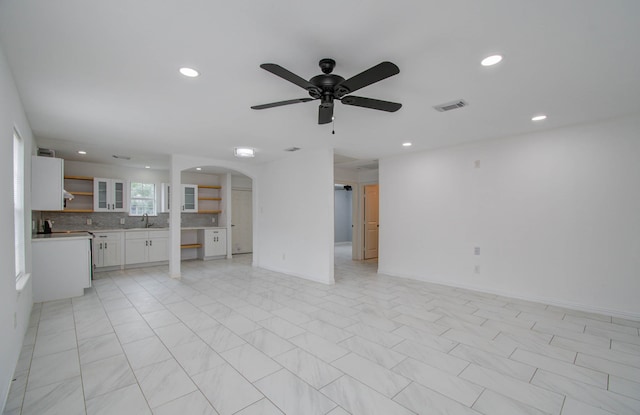 unfurnished living room with ceiling fan and sink