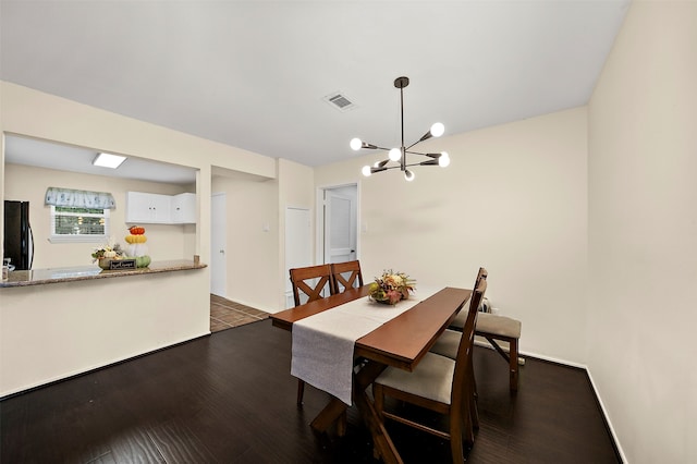 dining room with a notable chandelier and dark hardwood / wood-style floors