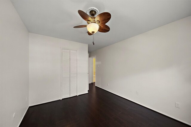 unfurnished bedroom with a closet, ceiling fan, and dark hardwood / wood-style flooring