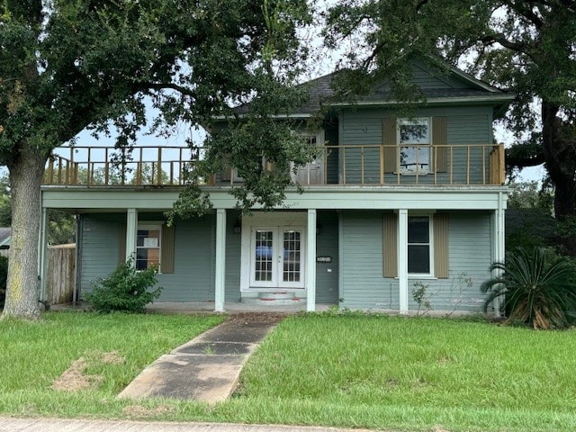 view of front facade featuring a balcony and a front lawn