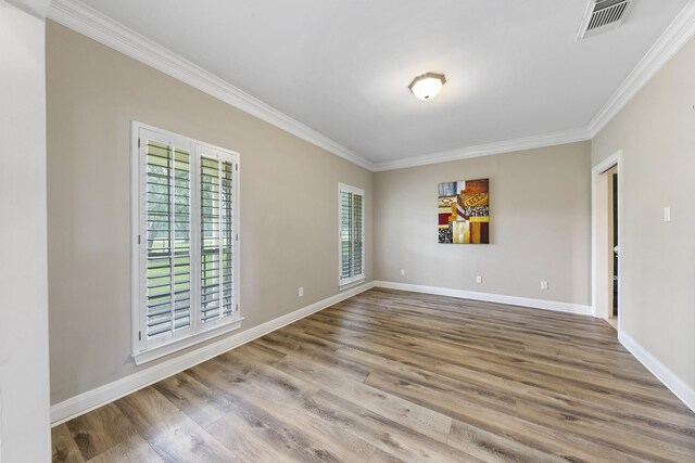 empty room featuring crown molding and hardwood / wood-style floors