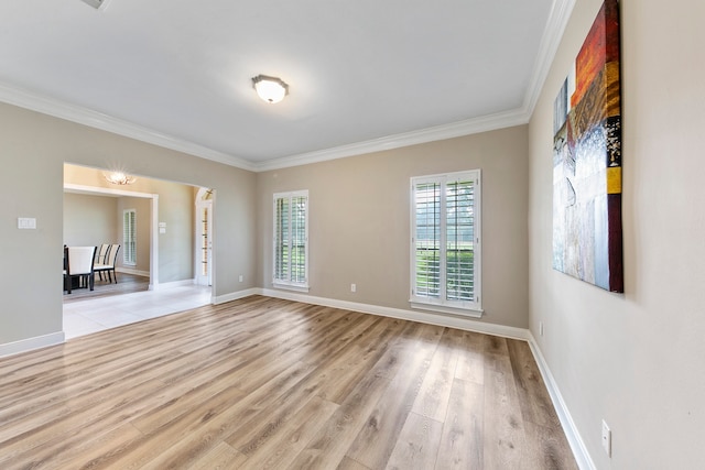 empty room featuring ornamental molding and light wood-type flooring