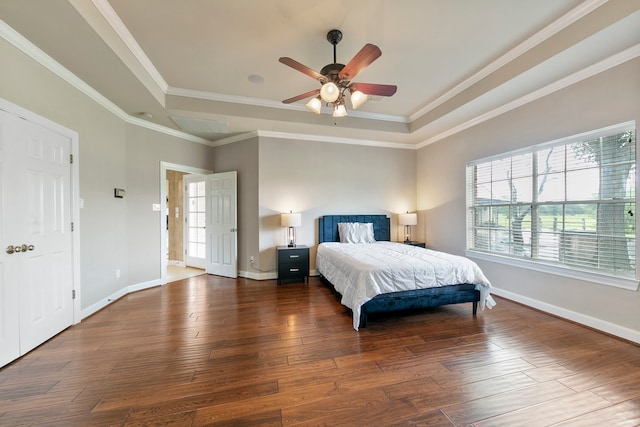 bedroom featuring ceiling fan, ornamental molding, a tray ceiling, and dark hardwood / wood-style flooring