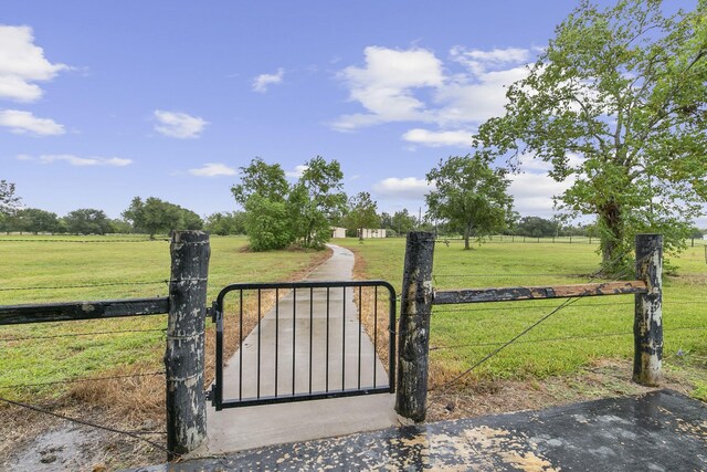 view of gate featuring a yard and a rural view