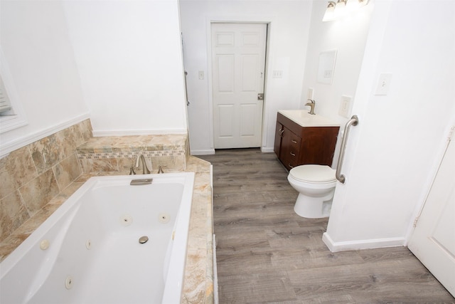 2620 W Shane St, Alvin, TX 77511 - bathroom with a whirlpool tub, wood finished floors, vanity, and toilet