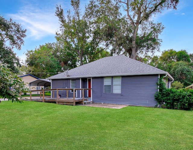 2620 W Shane St, Alvin, TX 77511 - rear view of property featuring a lawn, a wooden deck, roof with shingles, and a detached carport