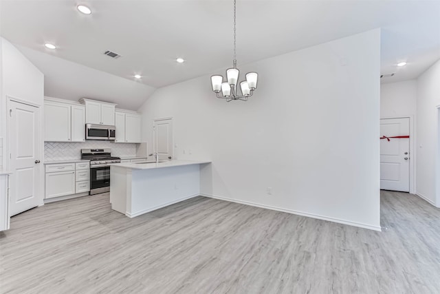 kitchen with white cabinets, light hardwood / wood-style flooring, decorative light fixtures, stainless steel appliances, and lofted ceiling