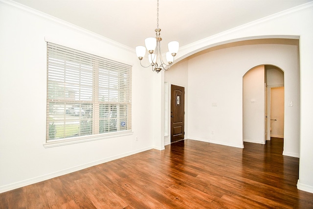 spare room with dark hardwood / wood-style floors, a chandelier, and ornamental molding