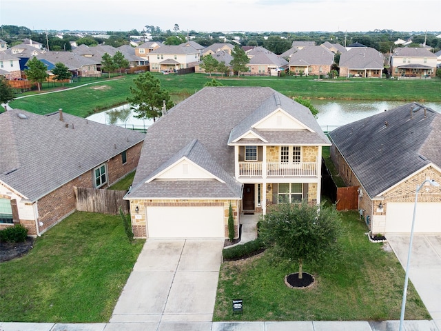 view of front of home featuring a water view, a garage, a front lawn, and a balcony